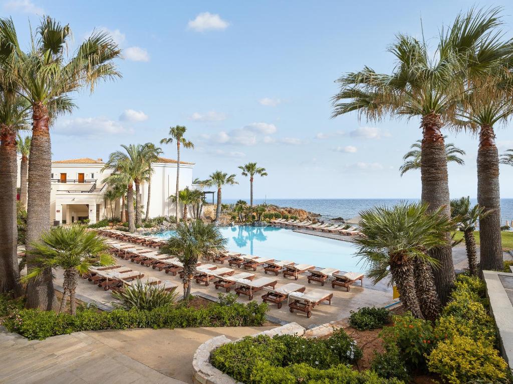 Grecotel Marine Palace & Aqua Park baseins ar palmām piekrastē