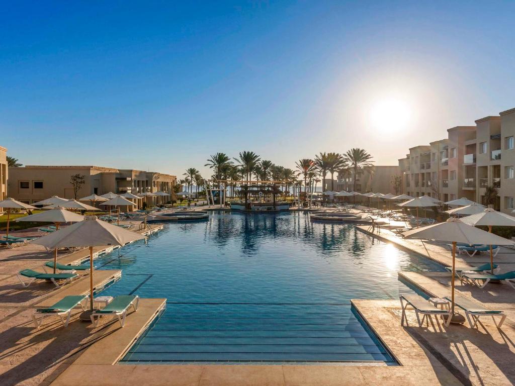 Rixos Premium Seagate Sharm baseins ar palmām un sauli
