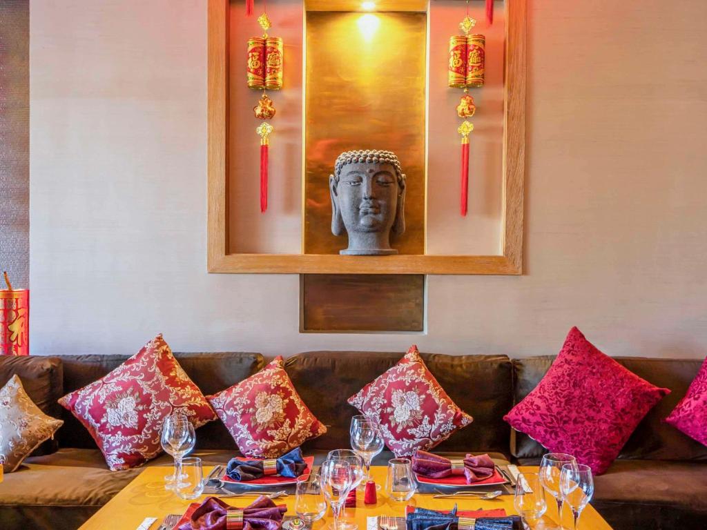 Restorāna interjers Rixos Premium Seagate Sharm ar Budas statuju un sarkaniem spilveniem.