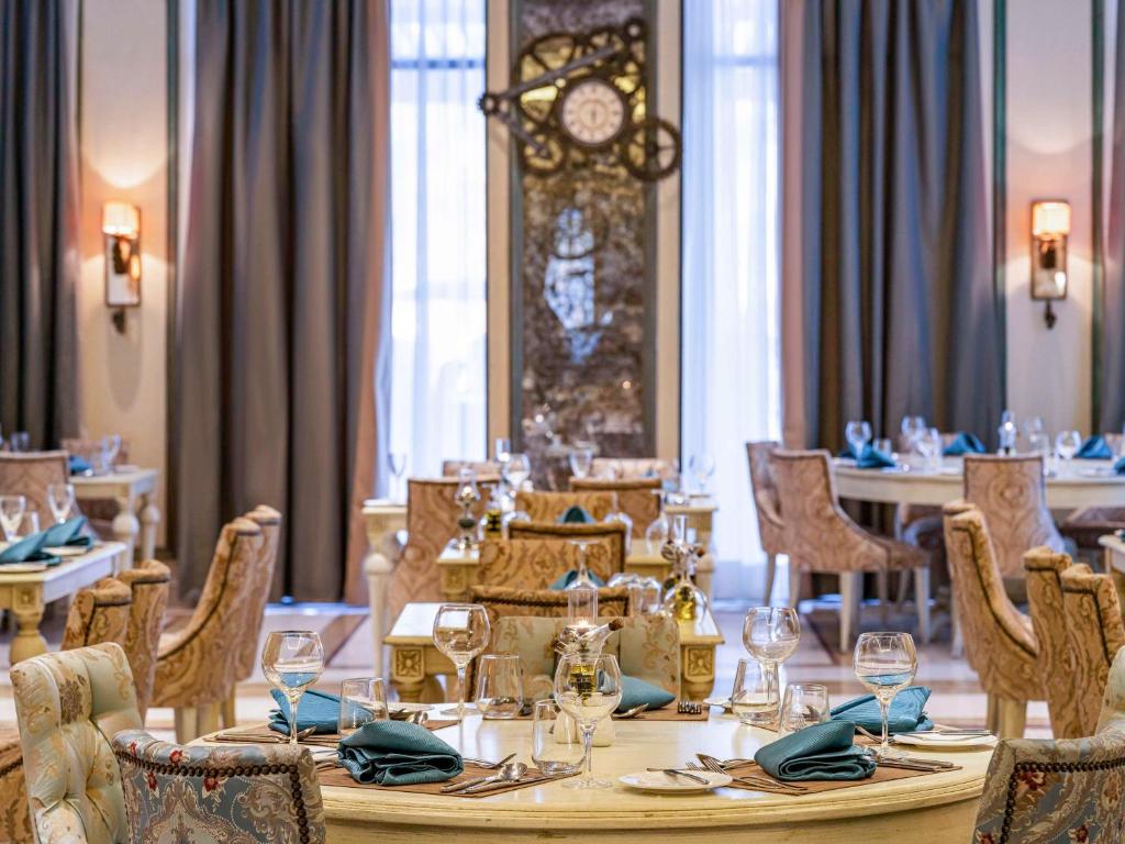 Elegants restorāns Rixos Premium Seagate Sharm ar gaumīgiem galdiem un krēsliem.