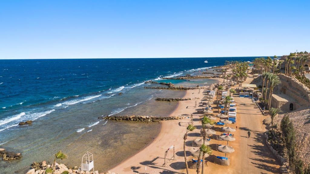 Piekrastes skats no Pickalbatros Citadel Resort ar pludmali un palmām.