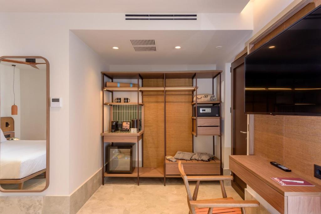 Moderns INNSiDE by Meliá Elounda numura aprīkojums ar atvērtā tipa skapi un TV.