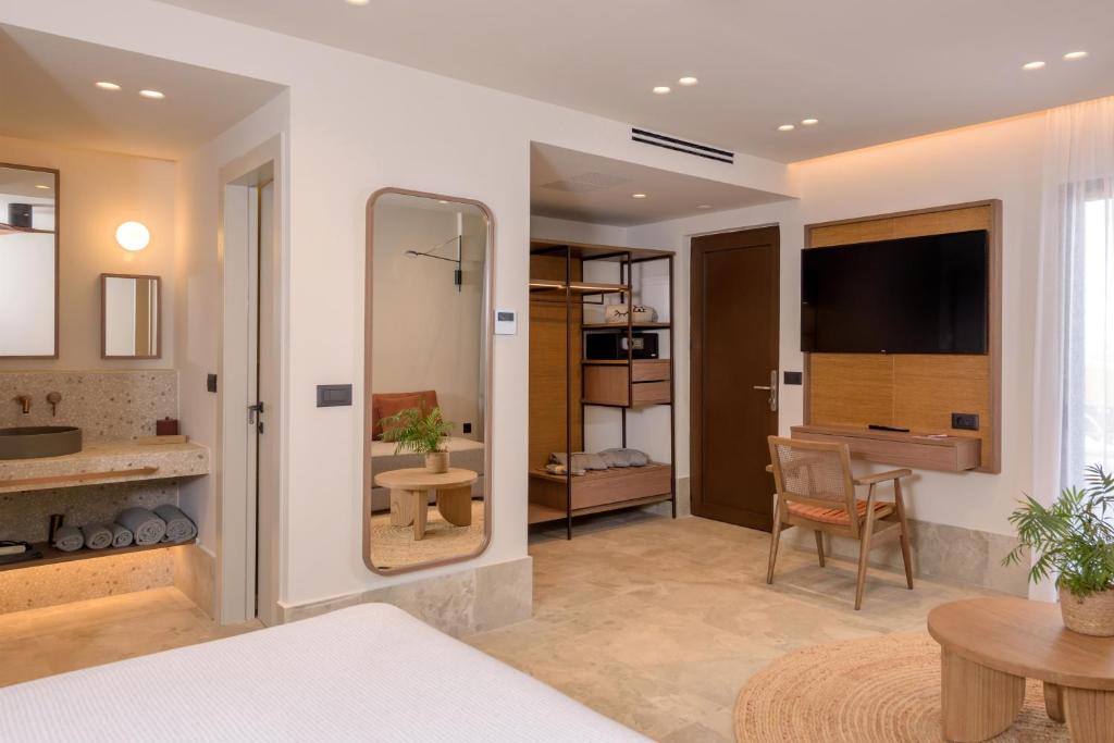 Gaišs un plašs viesnīcas numurs ar atvērta tipa vannas istabu un koka mēbelēm INNSiDE by Meliá Elounda.