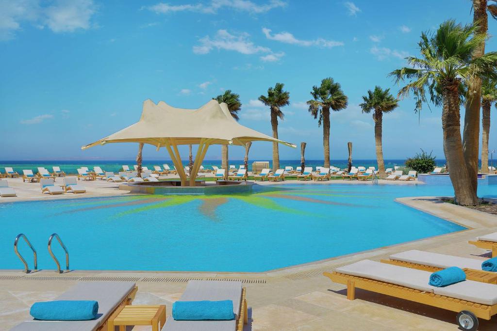 Hilton Hurghada Plaza baseins ar palmām piekrastē