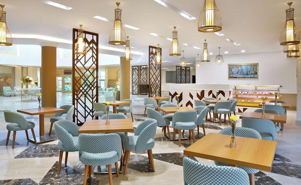 Moderns interjers kafejnīcā Hilton Hurghada Plaza ar stilīgiem galdiem un krēsliem.