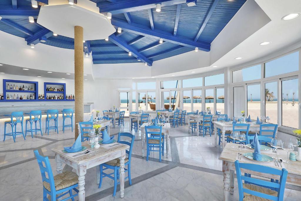 Mūsdienīgs restorāns ar zilu jumtu un jūras skatu Hilton Hurghada Plaza.