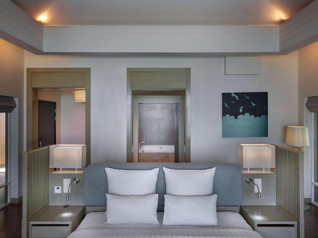 Mūsdienīgs viesnīcas numurs ar ērtu gultu, mīkstām spilveniem un modernu apgaismojumu. Sienas rotā mākslas darbs, un ir pieejamas divas durvis uz papildu telpām.