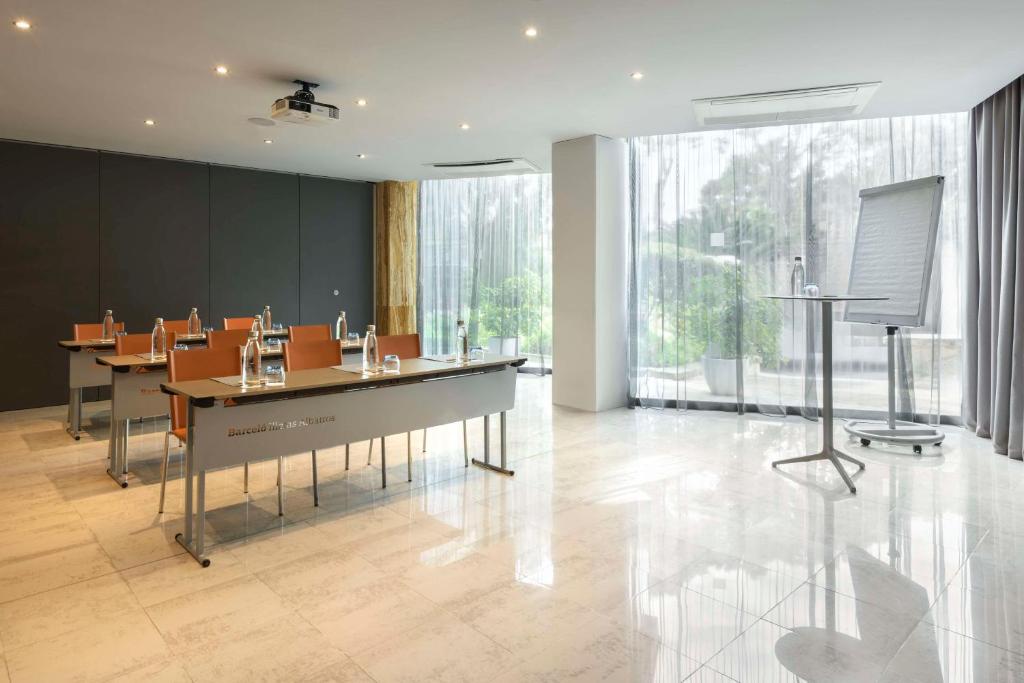 Mūsdienīga konferenču telpa ar dabiskiem apgaismojuma elementiem, galds un krēsli, kā arī projektors un flipcharts. Ideāla vide sanāksmēm un prezentācijām.