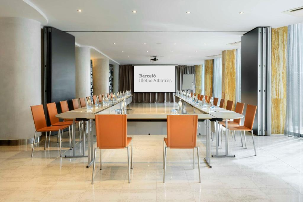 Konferences telpa ar garu galdu un oranžām krēsliem, uz ekrāna redzams "Barceló Illetas Albatros". Telpa ir gaiša un moderna, ar lieliem logiem un elegantu apdari.