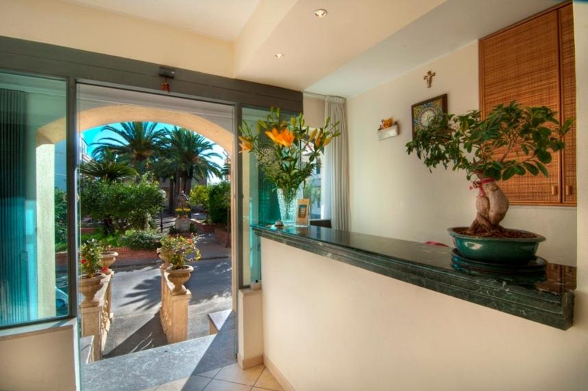 Receptes zona ar skatu uz dārzu, kurā redzami palmas un ziedi, ar modernu interjeru un akmens letēm.