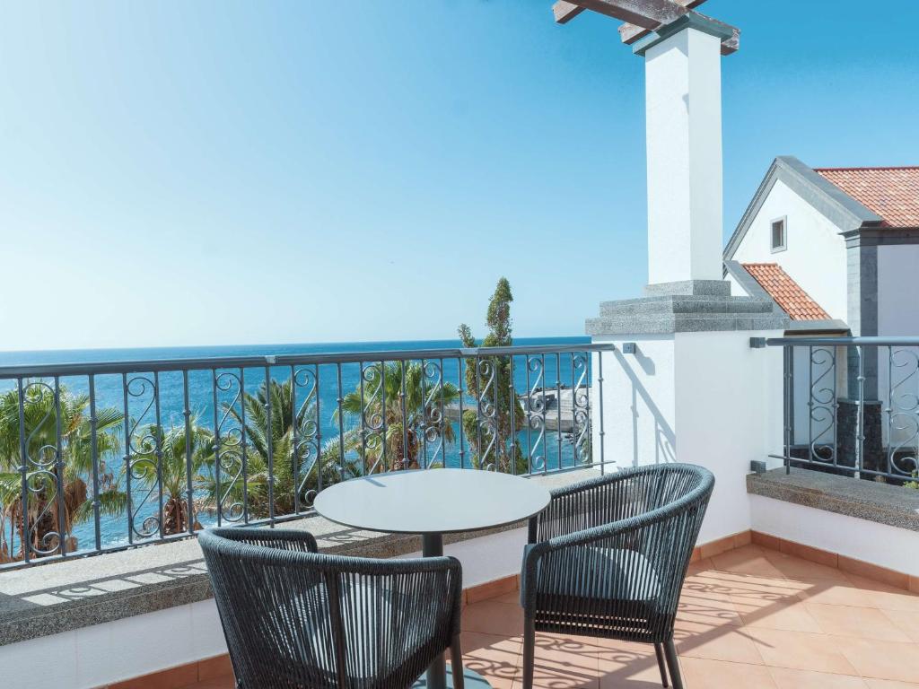 Balkons ar skatu uz okeānu un palmu kokiem Dreams Madeira Resort Spa & Marina