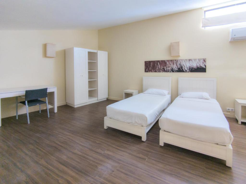 Divvietīgs numurs Be Cosy Apart Hotel ar divām atsevišķām gultām un rakstāmgaldu.