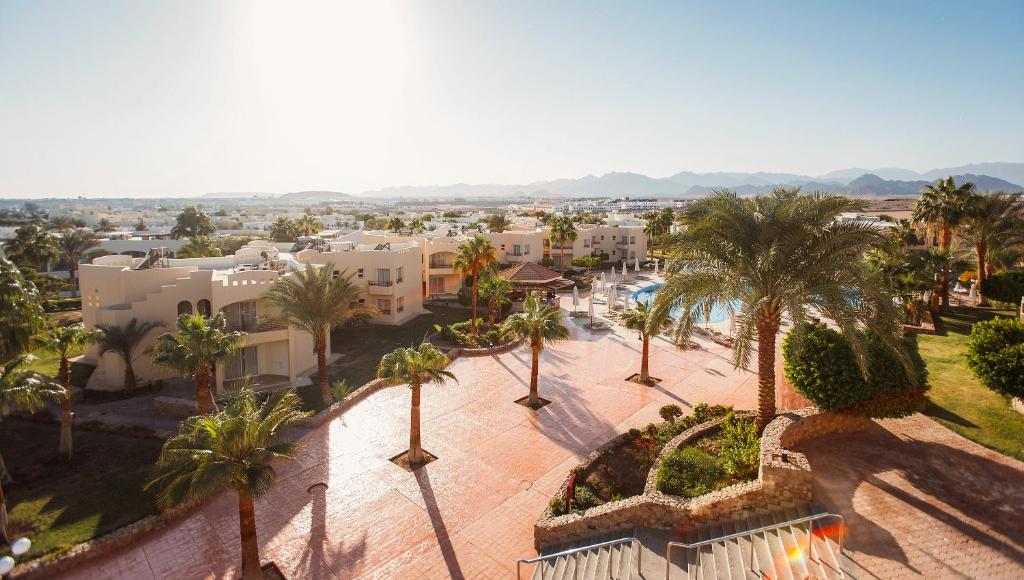 Saulaina skats uz Xperience Kiroseiz Parkland teritoriju ar baseinu un palmām.