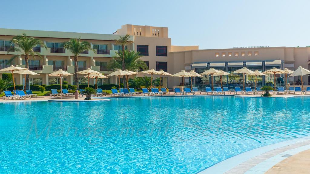 Peldbaseins ar sauļošanās krēsliem un palmu kokiem Xperience Kiroseiz Parkland