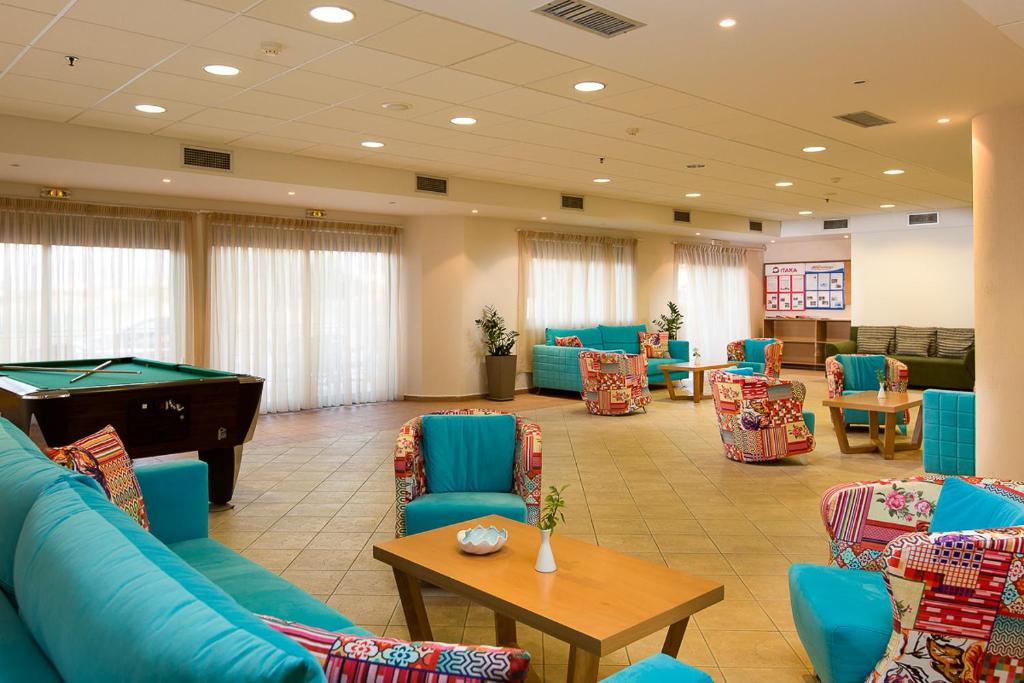 Mūsdienīga viesnīcas atpūtas zona ar spilgtiem dīvāniem, biljarda galdu un plašām logu konstrukcijām, kas nodrošina dabisku apgaismojumu. Ideāli piemērota relaksācijai un socializācijai.