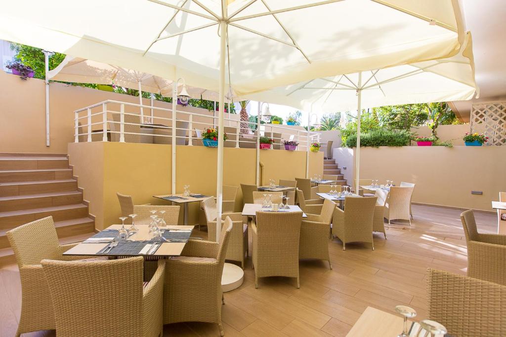 Skaists ārējais restorāns ar vīna galdiem un ērtām krēsliem, apkurēti zembaltiem saules jumtiem un zaļām puķu podiem. Ideāla vieta relaksācijai brīvā dabā.