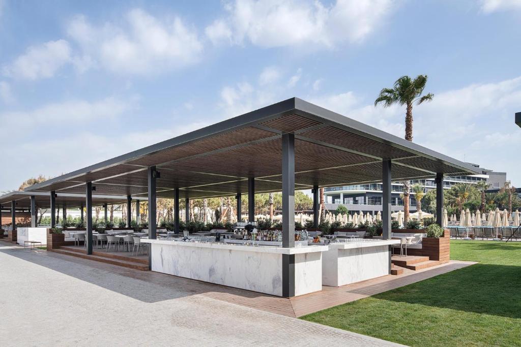 Āra restorāns pie Voyage Belek Golf & Spa ar modernu dizainu un palmām