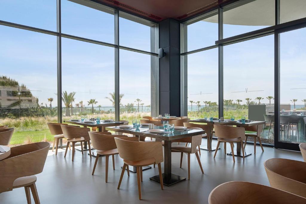 Mūsdienīgs restorāns ar lieliem logiem pie Voyage Belek Golf & Spa.