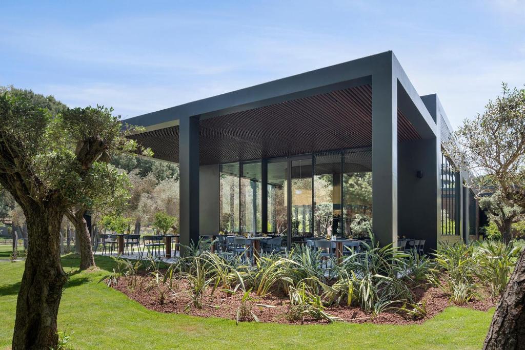 Mūsdienīgs restorāns viesnīcā Voyage Belek Golf & Spa, ieskauts dārzā.