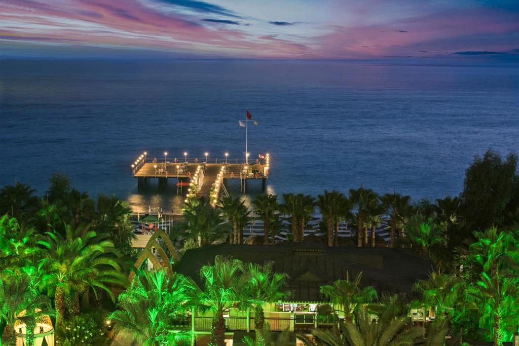 Skats uz Delphin Deluxe piekrasti un piestātni saulrieta laikā