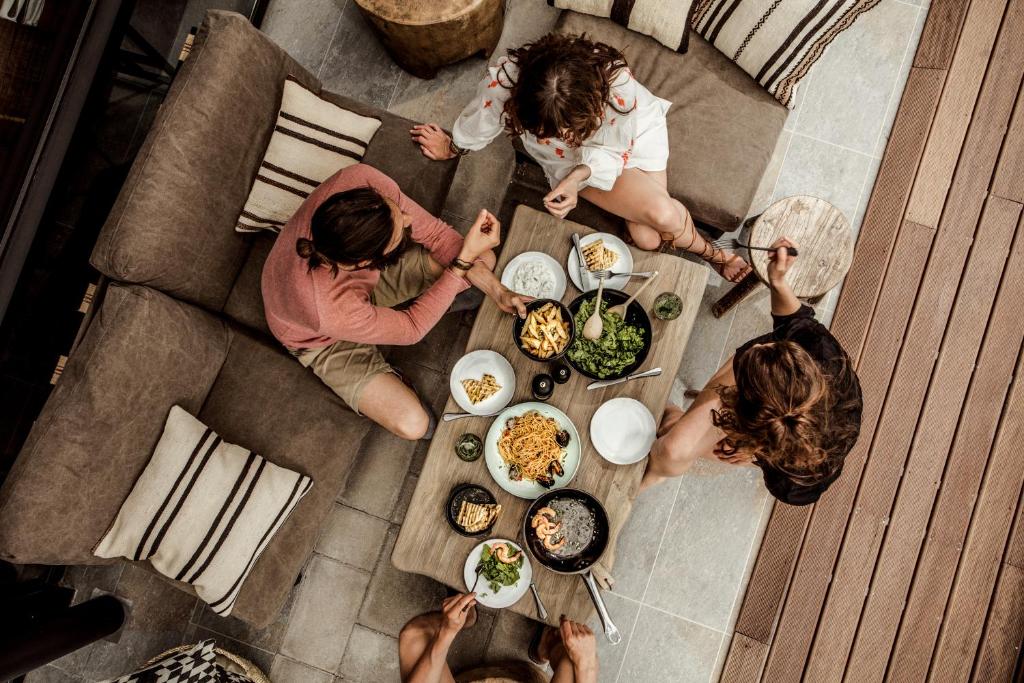 Viesnīcas Casa Cook Rhodes viesi izbauda gardu maltīti pie galda.