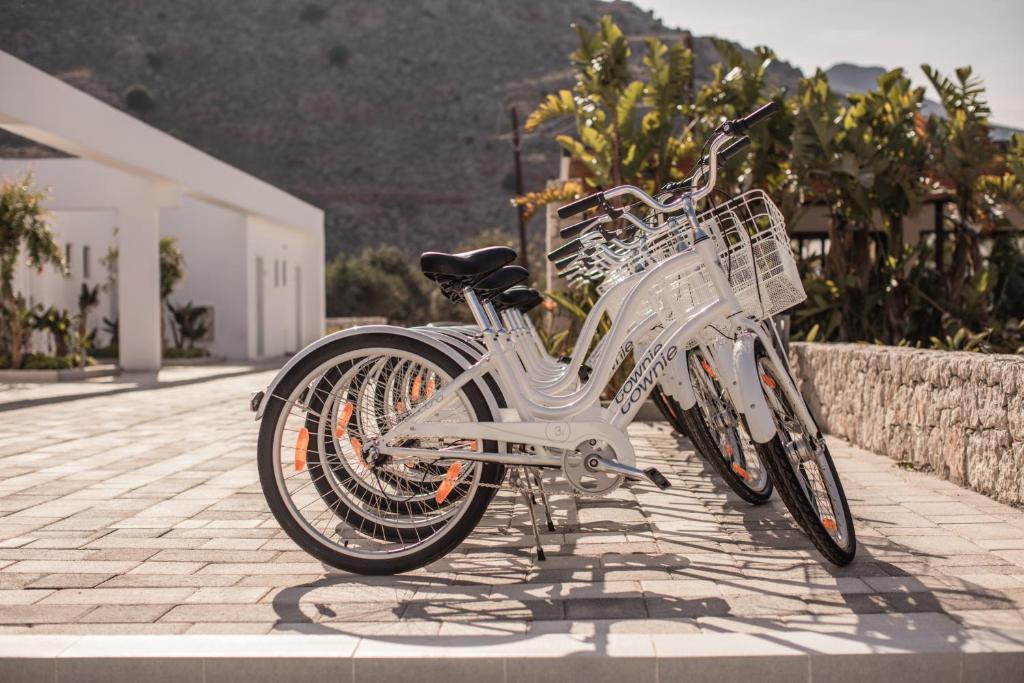 Baltas velosipēdi pie viesnīcas Casa Cook Rhodes, piekrastē.