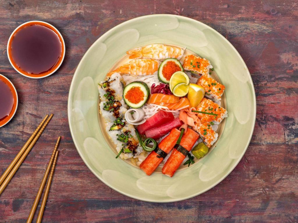 Dažādas suši uz šķīvja ar ēdamnūjām un sojas mērci