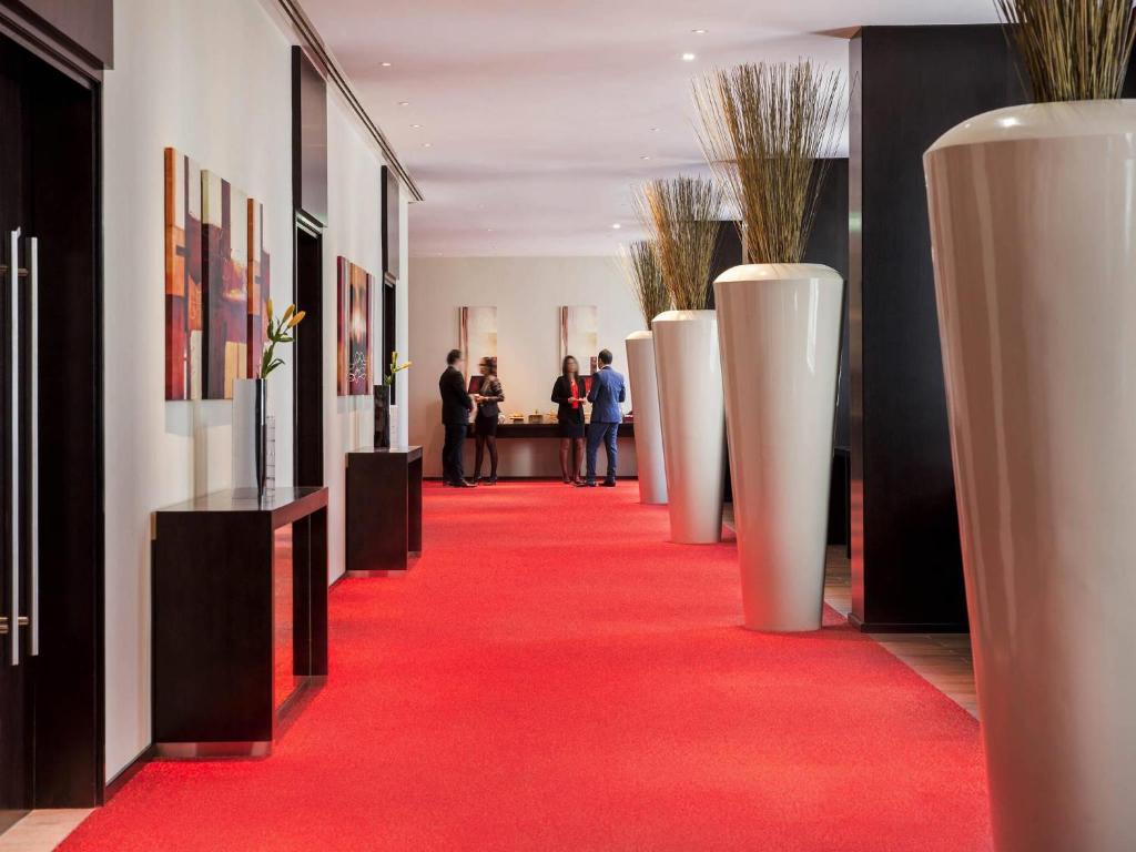 Ibis One Central Trade Center elegants vestibilājs ar sarkanu paklāju.