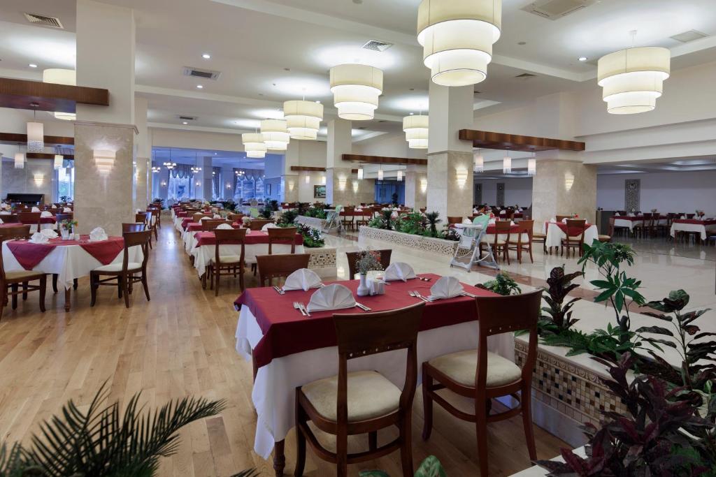 Saphir Resort & Spa restorāns ar elegantām galdiem un gaismas ķermeņiem.