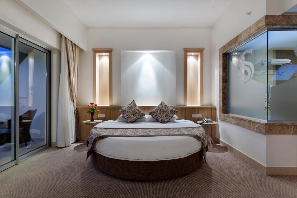 Mūsdienīgs numurs Saphir Resort & Spa ar apaļu gultu un balkonu.