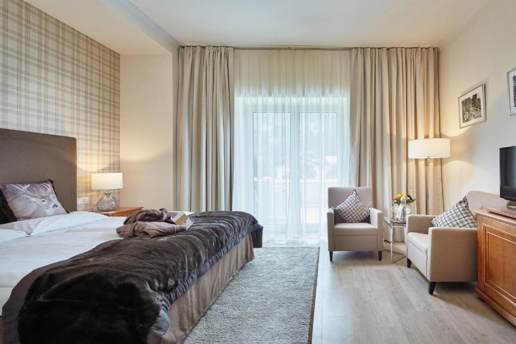 Moderns viesnīcas numurs ar ērtu gultu, mīkstiem krēsliem un plašu logu, caur kuru ieplūst dabiska gaisma. Interjers ir elegants ar neitrālām krāsām un patīkamiem aksesuāriem.