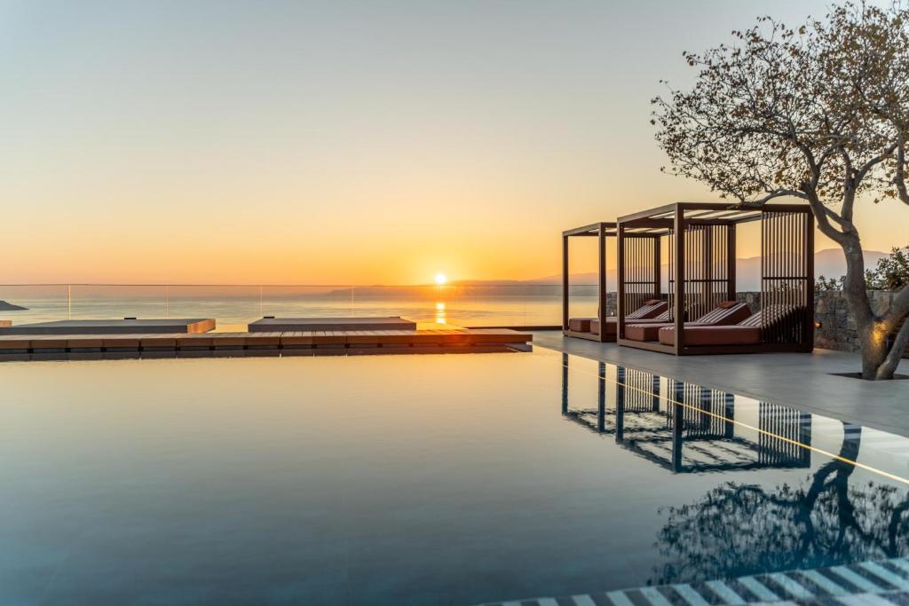 INNSiDE by Meliá Elounda bezgalības baseins un atpūtas zona saullēkta laikā