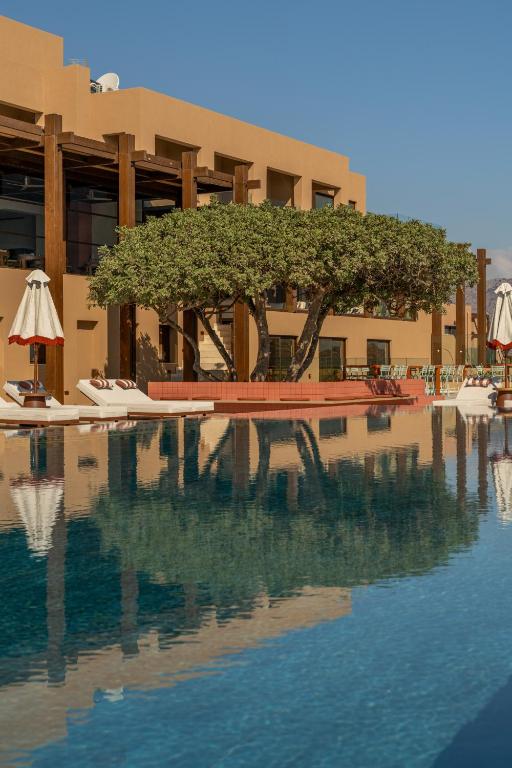 INNSiDE by Meliá Elounda āra baseins ar koka atspulgu un sauļošanās krēsliem.