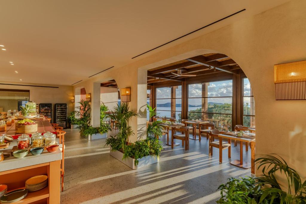 INNSiDE by Meliá Elounda restorāna bufete un ēdamzāle ar skatu uz jūru caur plašiem logiem.