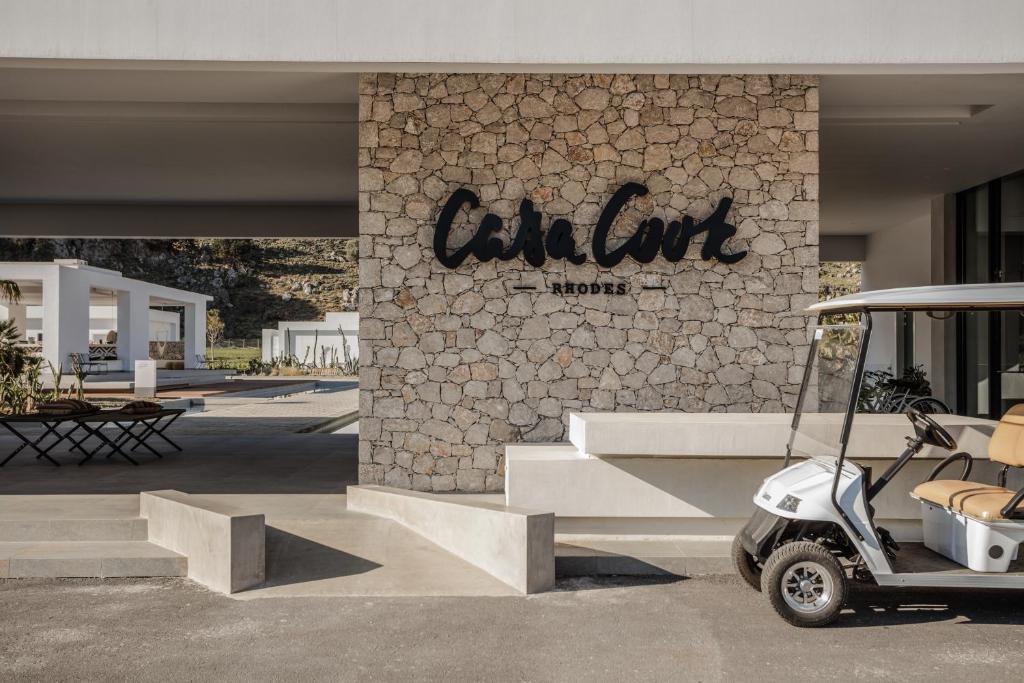 Casa Cook Rhodes ieeja ar akmens sienu un golfa ratiņiem