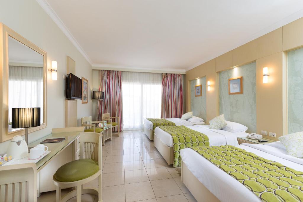 Numuri ar divām gultām un modernu interjeru Naama Bay Hotel & Resort.