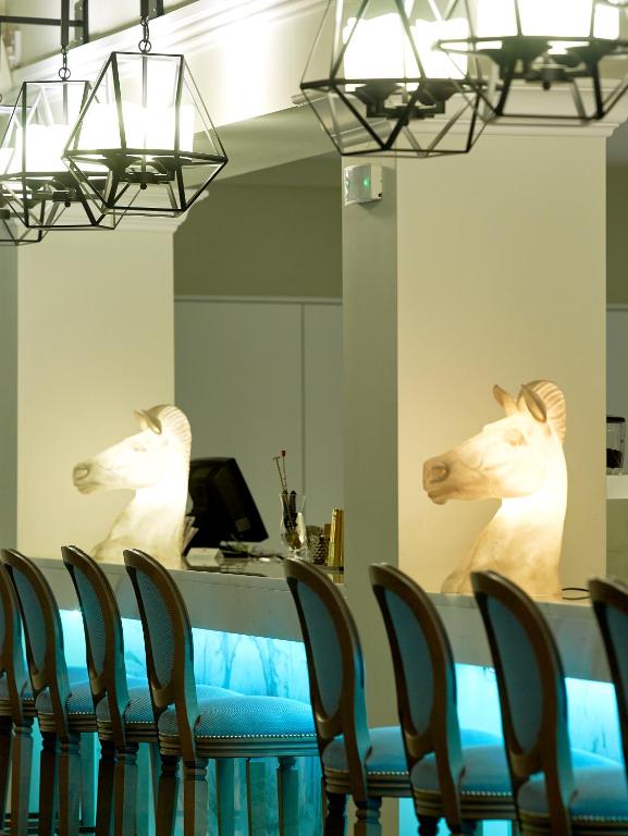 Elegants bārs ar izgaismotiem zirdziņu skulptūrām un modernām lampām, radot unikālu atmosfēru. Bāra letes apakšā ir zila gaisma, kas piešķir vietai mūsdienīgu pieskaņu.