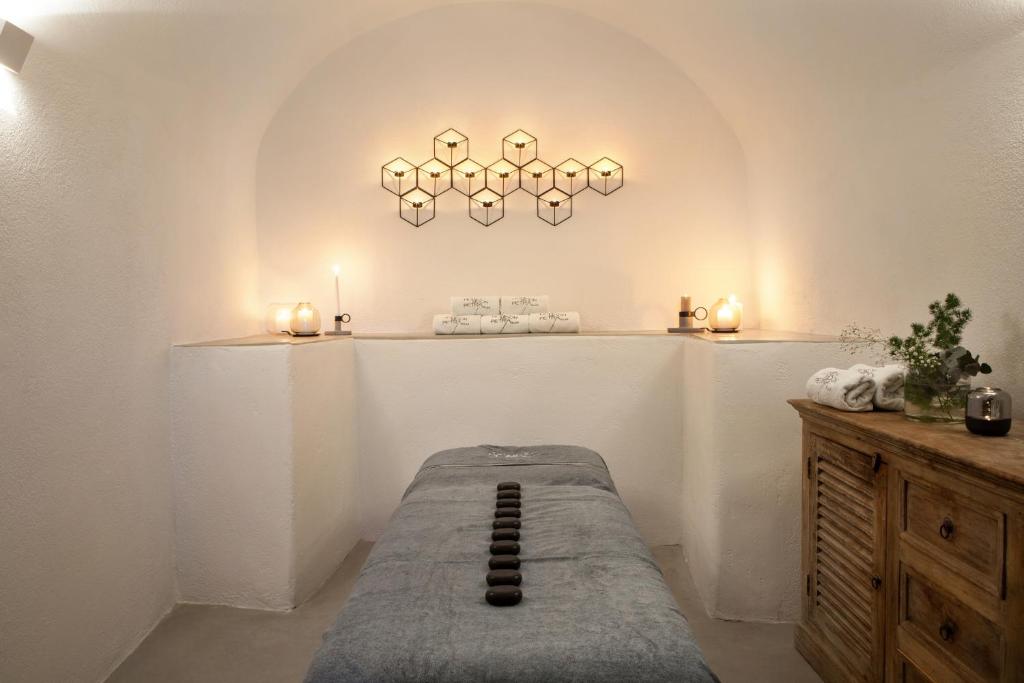 Mierīga un relaksējoša spa telpa ar masāžas galdu, akmeņiem, svečām un dekoratīviem elementiem. Ideāla atmosfēra atpūtai un labsajūtai.