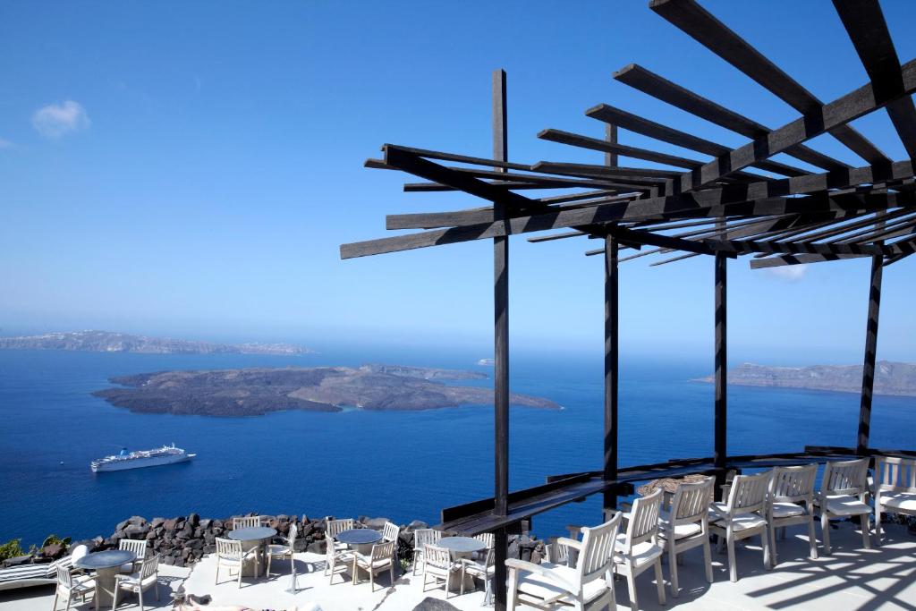 Skats uz jūru un salām no terases ar modernu koka konstrukciju, kas piedāvā mierīgu un relaksējošu atmosfēru. Jūras kuģis plūst pa zilo ūdeni, radot gleznainu ainavu.