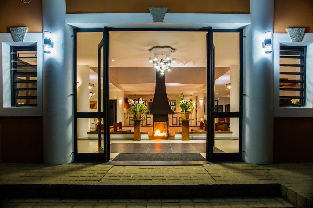 Hotel Plumeria moderna ieeja ar apgaismotu vestibilu.