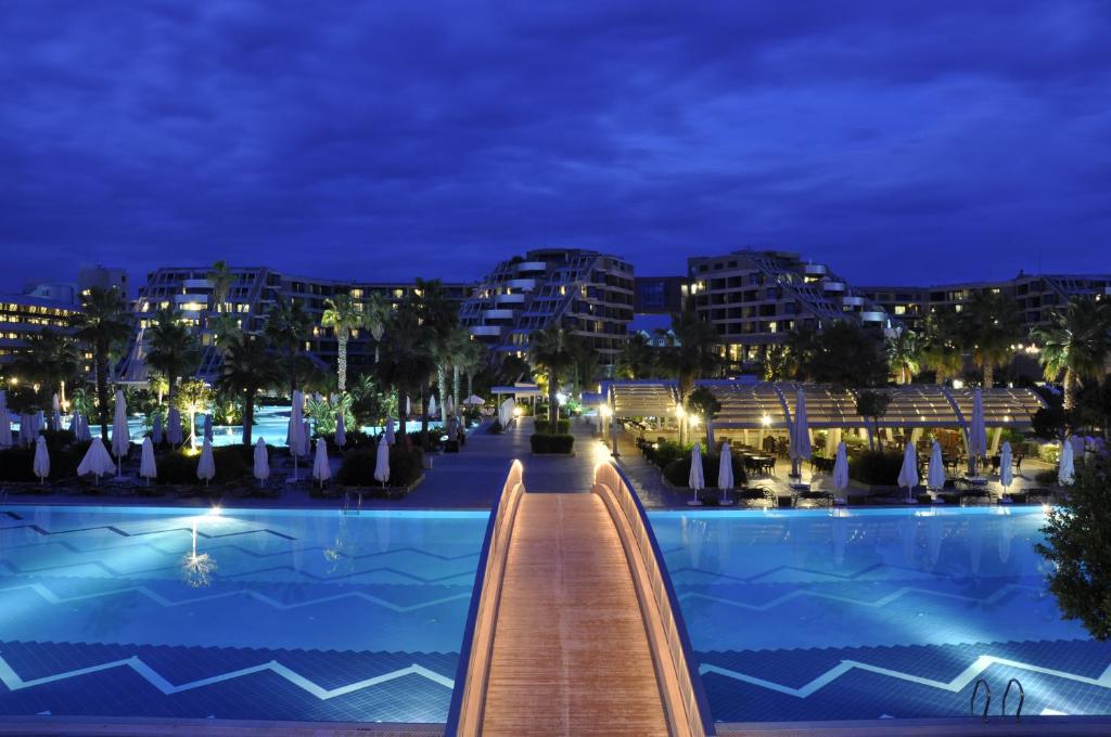 Susesi Luxury Resort baseins piekrastē ar apgaismojumu naktī
