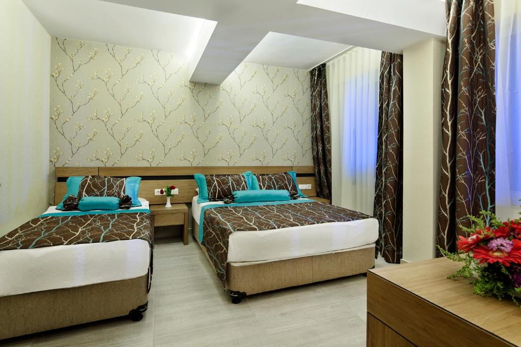 Elegants numurs ar divām gultām Saphir Hotel & Villas, dekorēts ar ziedu akcentiem.