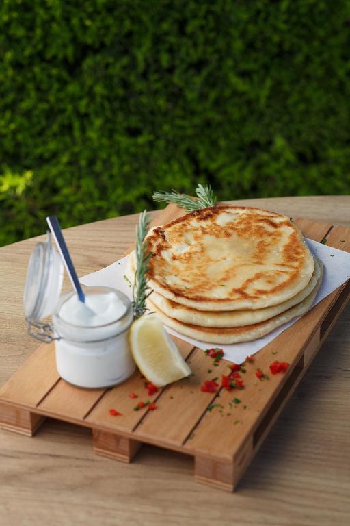 Gards plānais maizes klājs ar krējumu un citrona šķēlīti uz koka dēlīša.