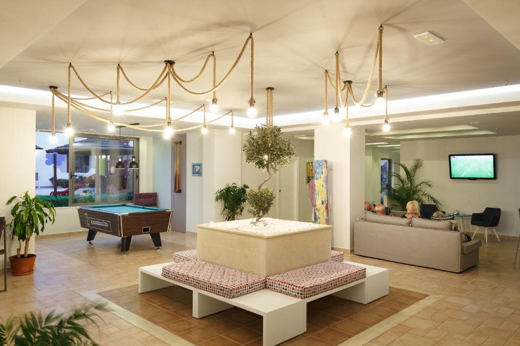 Mūsdienīgs interjers ar biljarda galdu, dīvāniem un greznu apgaismojumu, kas rada relaksējošu atmosfēru. Centrā ir apzaļumots stūris ar olīvu koku un māksliniecisku dekori.