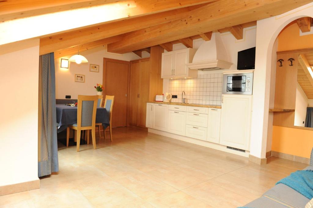 Gaiša un moderna dzīvokļa iekārtojuma aina ar atvērtu virtuvi un ēdamzonu, kurā ir koka sijas un silti toņi. Ideāli piemērota atpūtai vai īslaicīgai uzturēšanās vietai.