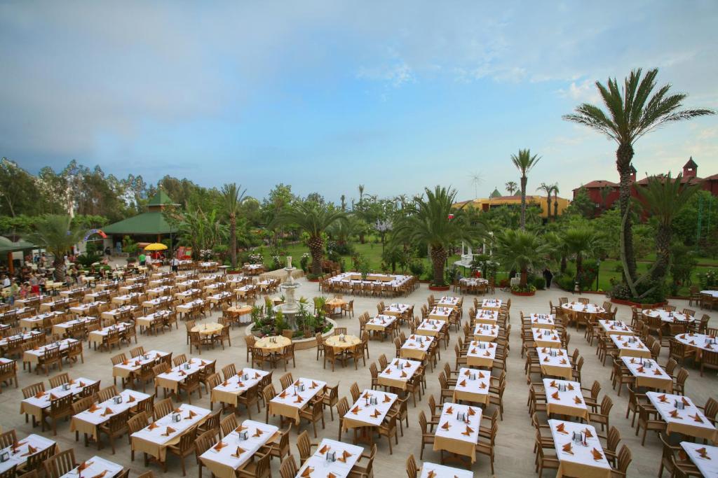 Saphir Hotel & Villas āra restorāns ar galdiem un palmām