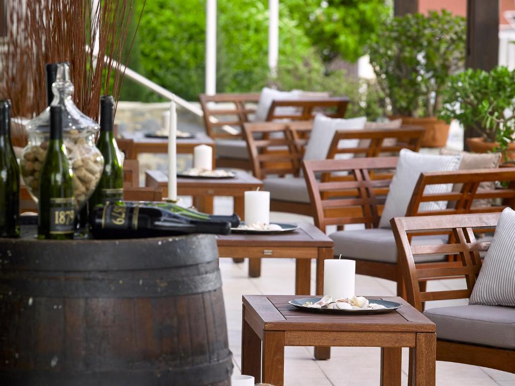 Albatros Spa & Resort terase ar elegantām mēbelēm un vīna pudelēm