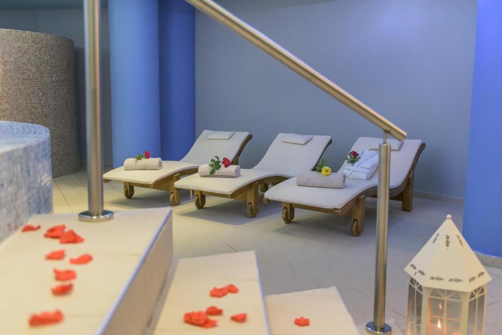 Atpūtas zona spa ar diviem atpūtas krēsliem, kas dekorēti ar ziediem, un mierīgu, relaksējošu atmosfēru. Sākuma posmā redzams arī gaismas elements un ziedlapiņas uz grīdas.