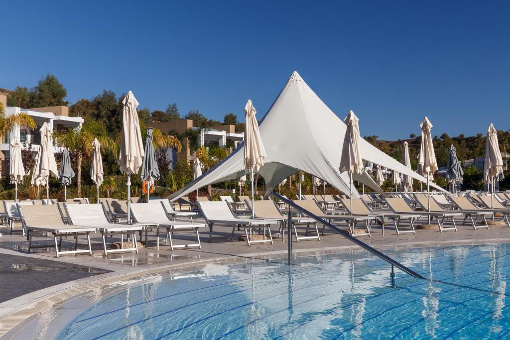 Viesnīcas Princess Andriana Resort & Spa baseins ar saulessargiem un atpūtas krēsliem