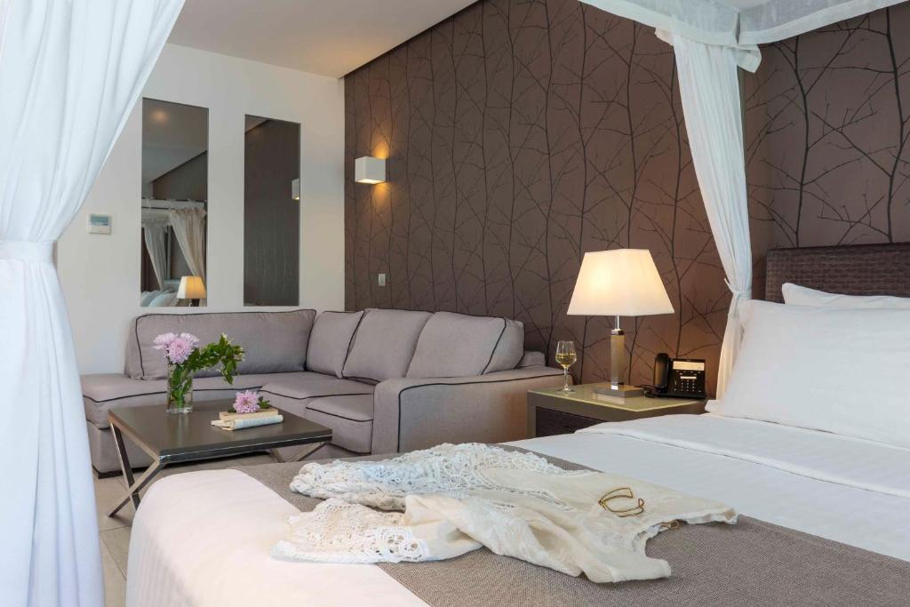 Mūsdienīgs numurs Princess Andriana Resort & Spa ar dīvānu un gultu.